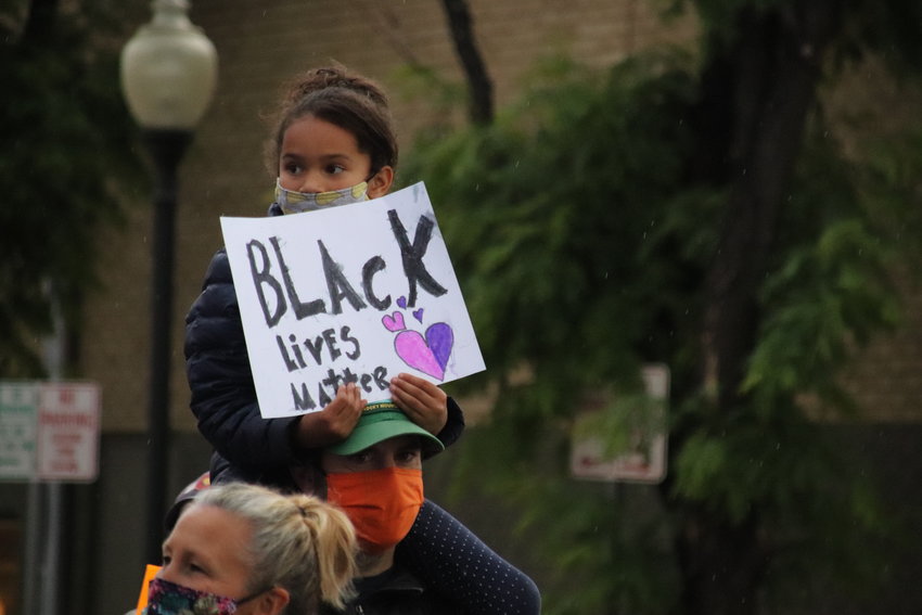 A girl carries a sign along the route of the Black Lives Matter Solidarity Walk in Littleton on June 18.